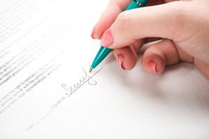 female hand signing a contract.